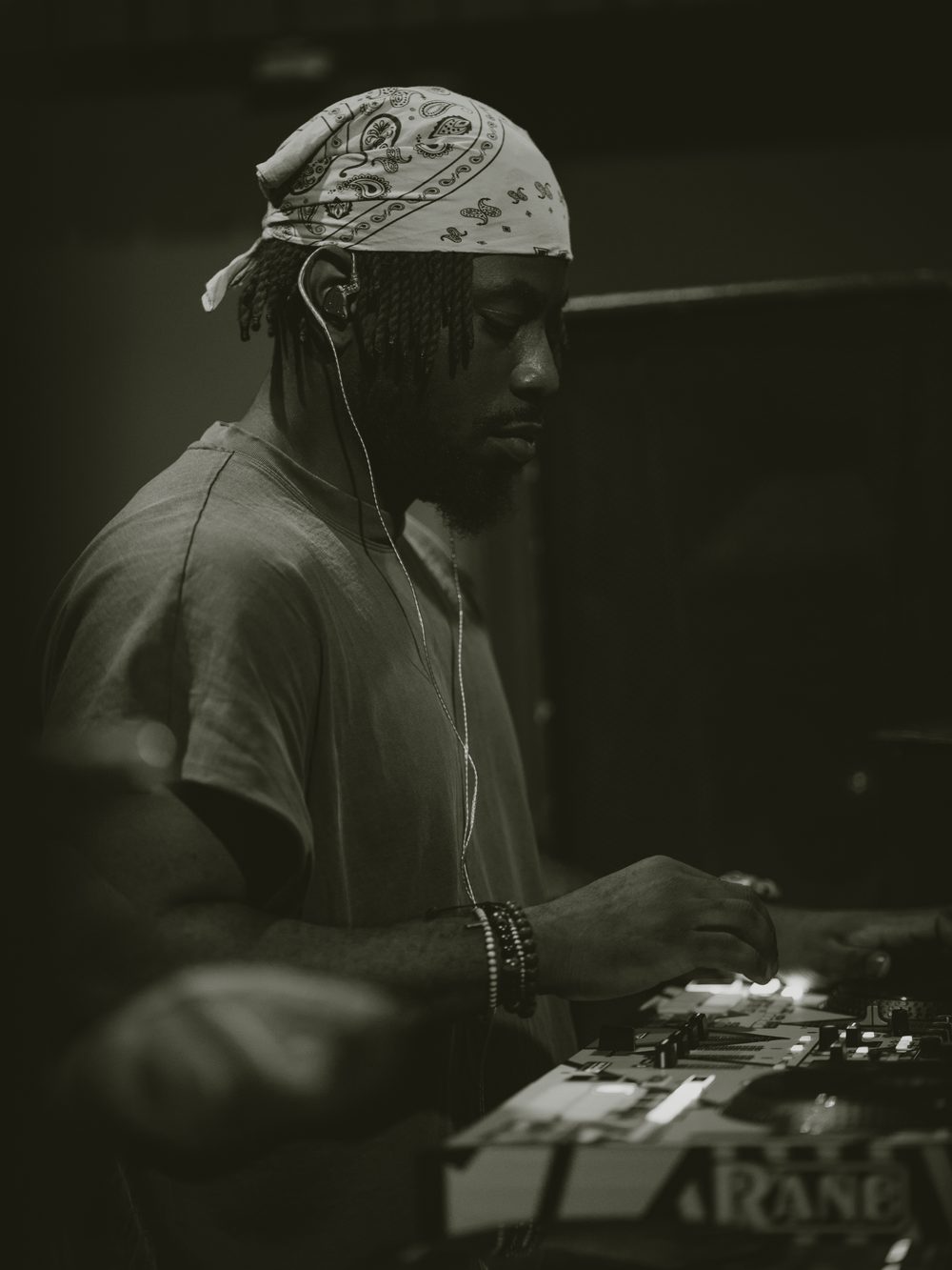 Black and white shot of DJ Papi mixing on the decks